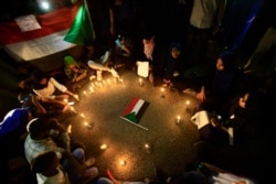 Sudanese protesters take part in a vigil in the capital Khartoum to mourn dozens of demonstrators killed in a brutal raid on a Khartoum protest, July 13, 2019.