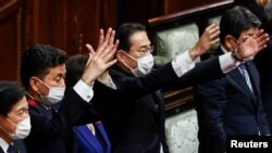 日本首相岸田文雄（中）2021年10月14日在解散众议院后挥手打气（路透社）
