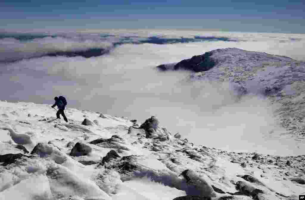 Clouds fill Tuckerman Ravine below Peter Arthur as he makes the final push to the summit of 1,917-meter Mount Washington in New Hampshire.