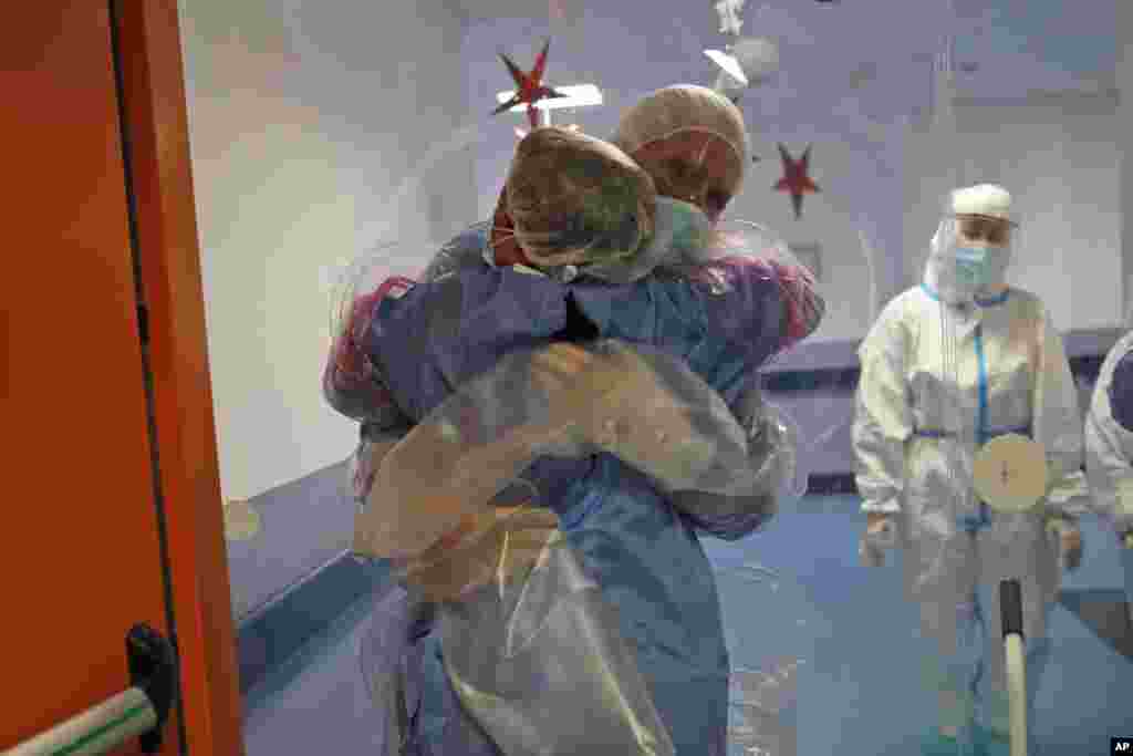 Ela Gubbiotti hugs her partner Giancarlo Vannimartini, an anesthesiologist who has been hospitalized for 10 days, in a safe room where patients and relatives can hug each other protected by a plastic film screen set up inside the COVID-19 ward of the Ospedale dei Castelli Hospital in Ariccia, near Rome, Italy.
