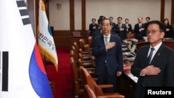韩国代理总统兼总理韩德洙在首尔政府大楼主持内阁会议