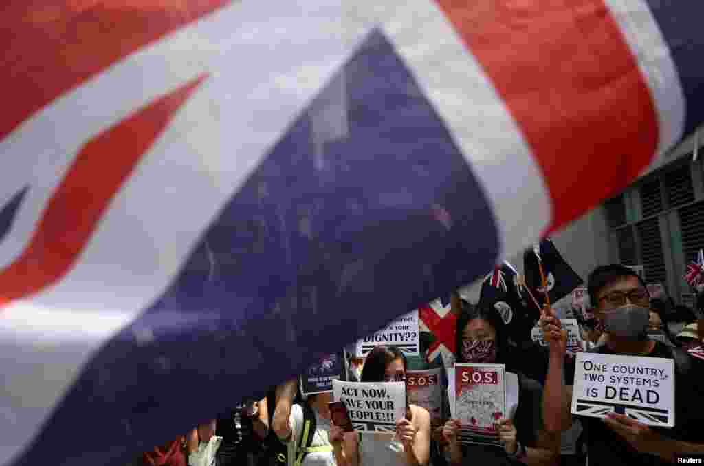 抗议者举着旗帜和标语以及英国国旗在英国驻香港领事馆外集会,呼吁伦敦正视北京破坏《中英联合声明》的问题。(2019年9月15日)