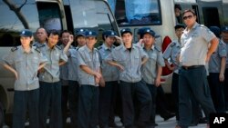 保安人员监视和阻止美联社记者拍摄中国政府人员拆毁浙江省永嘉县大沸下天主堂十字架。（2015年7月30日）