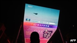 资料照片：一位男子观看中国在台湾周边进行“联合利剑”军事演习的新闻。(2024年10月14日)