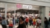 FILE - Shoppers walk past South Africa's Mr Price clothing store in Johannesburg. First National Bank of South Africa says its cardholders made purchases worth more than 2.5 billion rand last Black Friday, and a sizable jump was expected this year.