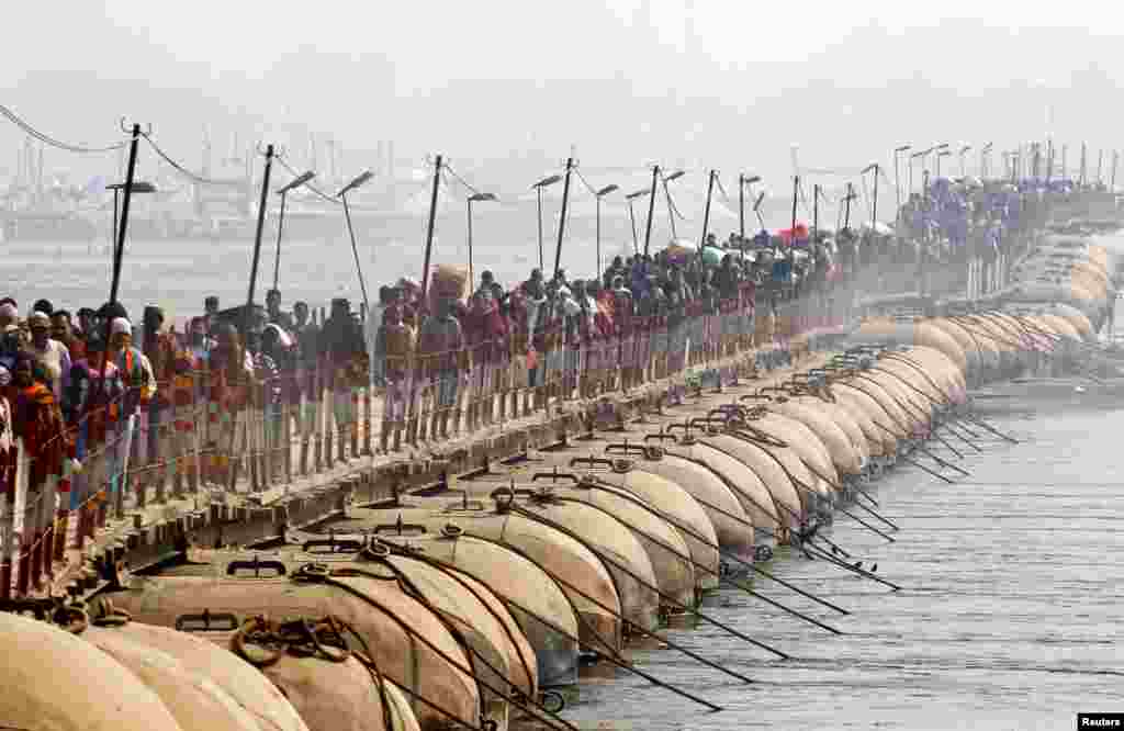 Devotees cross a pontoon bridge after taking a holy dip at Sangam, the confluence of the Ganges, Yamuna and Saraswati rivers, during Magh Mela festival in Allahabad, India.