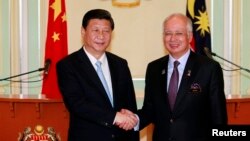 2013年10月4日吉隆坡附近纳吉办公室：中国国家主席习近平（左）和马来西亚总理纳吉布握手