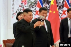 2018年6月19日，中国国家主席习近平和朝鲜领导人金正恩在欢迎宴会上举杯祝福。