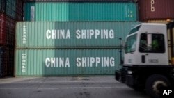 资料照：在乔治亚州萨瓦纳港，一辆卡车驶过中国海运集团的集装箱。(2018年7月5日)