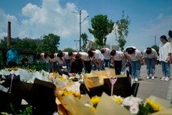 河南郑州市民在地铁5号线站台前给洪灾死难者献上鲜花，鞠躬致哀。（2021年7月27日）