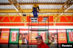 巴西工人在圣保罗世界杯赛场附近安装国际足联赞助商的广告牌（资料照片）