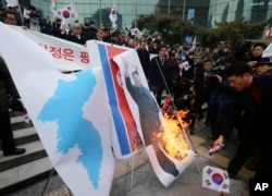韩国民众在首尔火车站抗议朝鲜代表团来访，焚烧了印有朝鲜领导人金正恩的画像 (2018年1月22日)