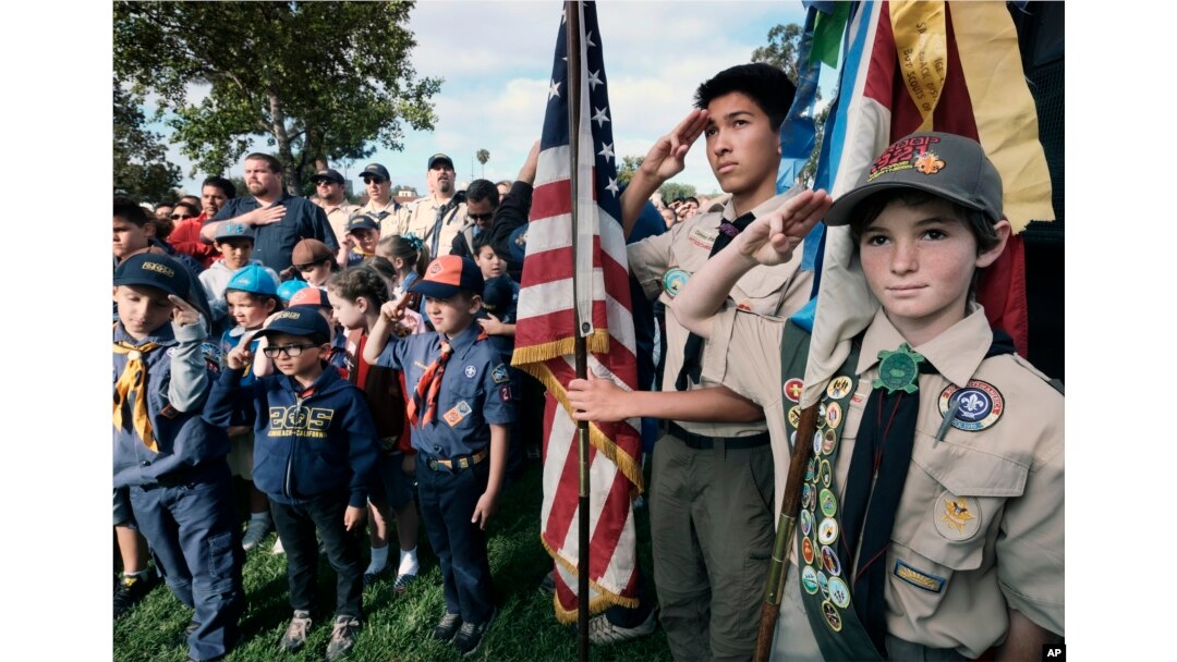 FILE - Boy Scouts and Cub Scouts salute the flag during ceremonies at the Los Angeles National Cemetery in Los Angeles, May 26, 2018.