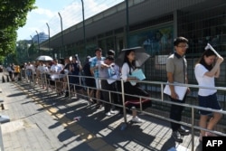 2018年7月26日，人们在北京的美国大使馆外面排队申请签证。
