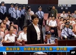 中央电视台画面显示薄熙来妻子谷开来(中间站立者)2012年8月9日在中国东部的合肥市中级人民法院出庭受审