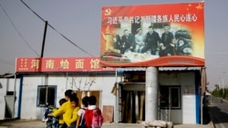 资料照片：新疆和田一家面馆上树立的中国领导人习近平与维吾尔族老人在一起的照片。（2018年9月20日）