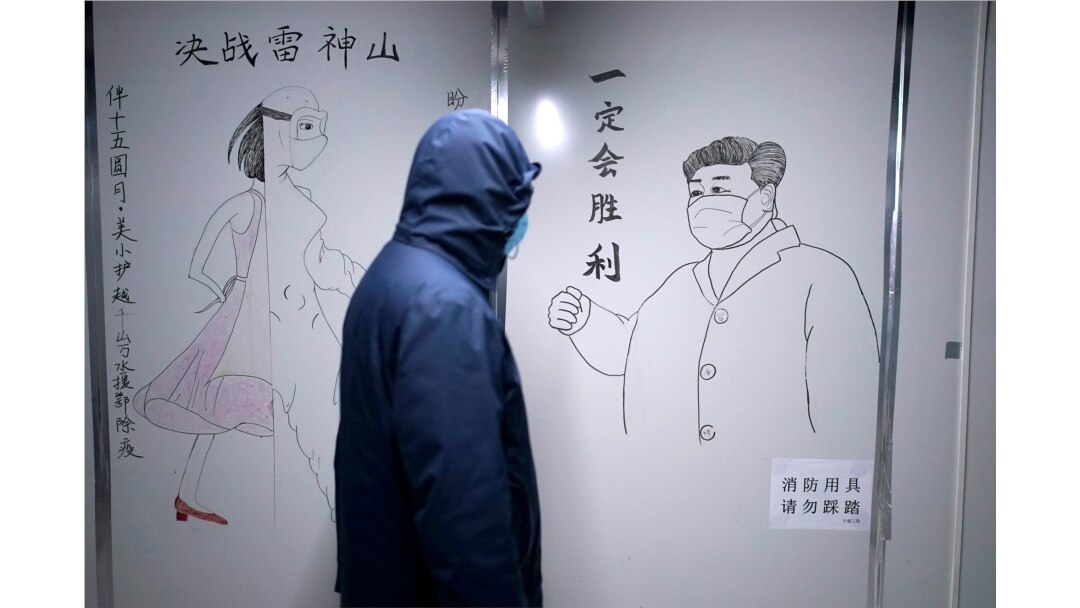 一名男子走過武漢疫情期間的一幅宣傳習近平的畫像