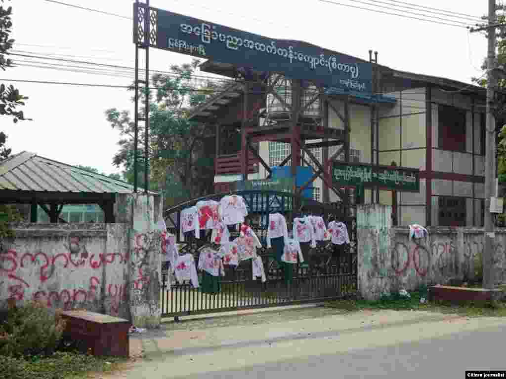 School uniforms with red stains to represent bloody crackdowns by Myanmar security forces during anti-coup protest are displayed on the gate of a high school in Myitkyinar, the capital of Kachin State.