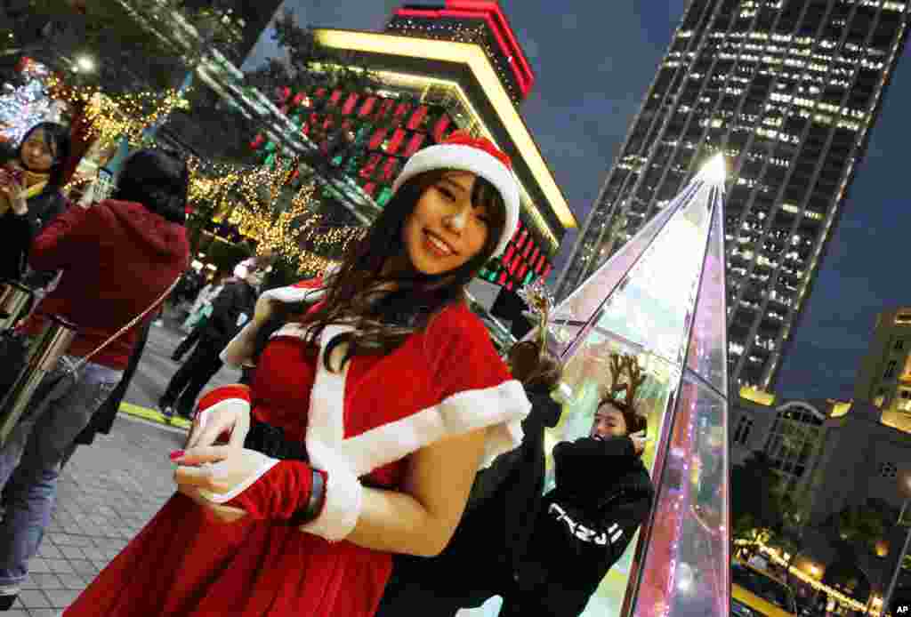 2017年12月22日,台湾台北,一位“秀女”(show girl )穿着圣诞节服装,在商店的圣诞节装饰前微笑。