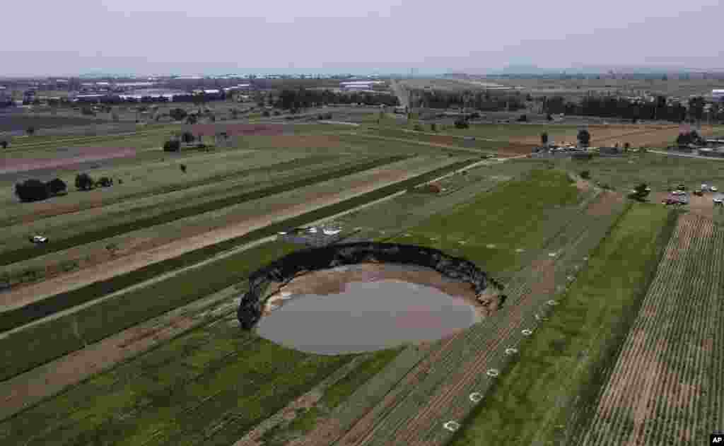 A water-filled sinkhole grows on a farming field in Zacatapec, on the outskirts of Puebla, Mexico.