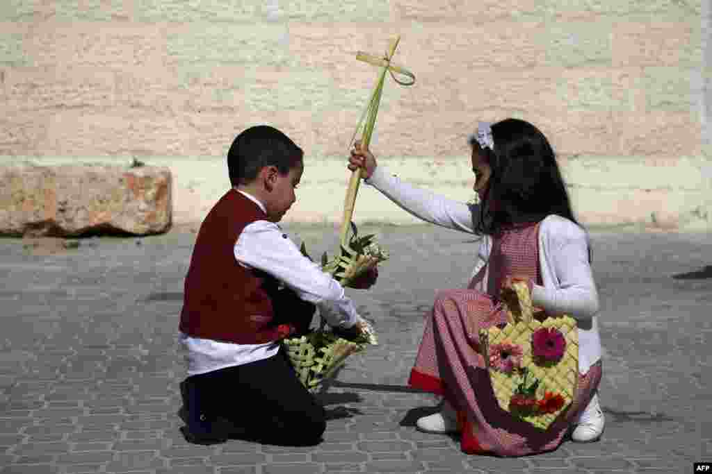 A Palestinian boy and a girl a cross as they attend Easter prayers at the Church of Saint Porphyrius in Gaza City.