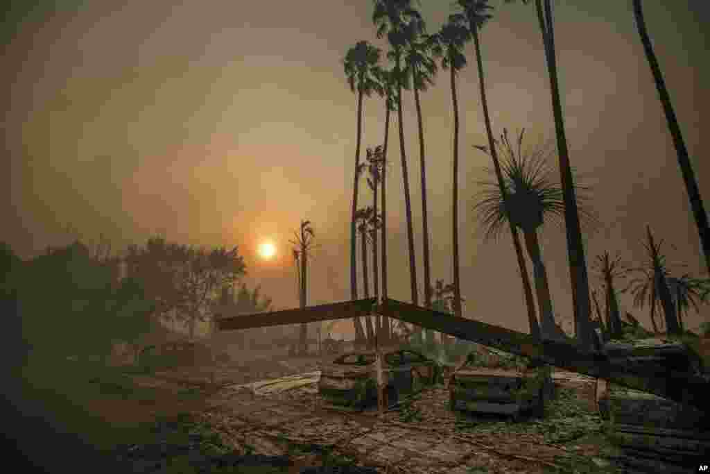 Smoke rises behind an apartment complex that has been leveled by flames as a wildfire ravages Ventura, California.