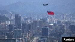 一架悬挂台湾旗帜的支奴干直升机在台北市上空飞行。（2021年10月7日）