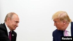 На фото: президент США Дональд Трамп та президент Росії Володимир Путін спілкуються під час саміту G20 у Японії у червні 2019-го року