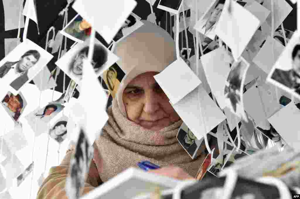 A woman writes a note in the golden book inside the memorial of victims, in front of the International Criminal Tribunal for the former Yugoslavia (ICTY) in The Hague, prior to the verdict in the genocide trial of former Bosnian Serbian commander Ratko Mladic. United Nations judges in sentenced Mladic, dubbed the "Butcher of Bosnia", to life in jail for crimes committed during the 1992-1995 war that killed 100,000 people as ethnic rivalries tore apart Yugoslavia.