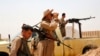 FILE - Members of Kurdish security forces patrol after clashes with Islamic State militants in the village of Bashir, south of the city of Kirkuk, Iraq, June 29, 2014.