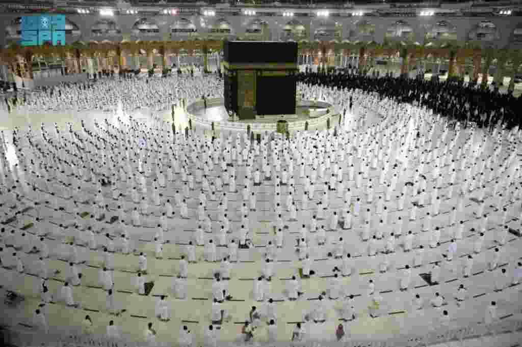 Muslims, maintaining social distancing, perform late night prayers on the night of 27th Ramadan in the Grand Mosque during the holy month of Ramadan, in the holy city of Mecca, Saudi Arabia. (Credit: Saudi Press Agency)