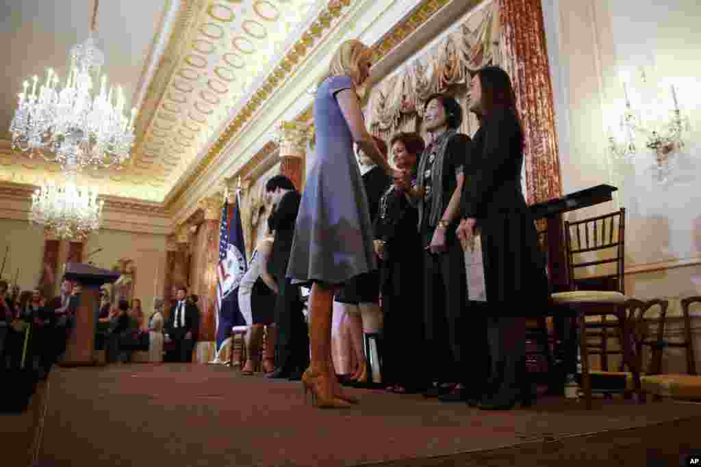 在美国国务院,伊万卡·特朗普会见一些致力于阻止人口贩卖而受到美国国务院有关年度报告表彰的模范,她正在和台湾的李丽华握手,右侧的人是泰国的 Boom Mosby(2017年6月27日)。