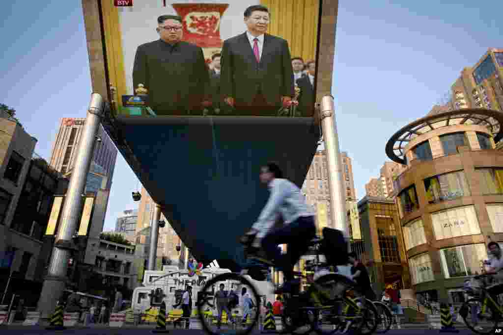 北京街头巨大的电视屏幕显示北京人民大会堂的欢迎仪式中中国国家主席习近平和朝鲜领导人金正恩(2018年6月19日)。朝鲜官方的朝中社说,金正恩感谢中国国家主席习近平支持他和美国总统川普上星期在新加坡举行的历史性峰会。金正恩还说,平壤和北京进入了双边合作与友谊的新时代。华盛顿智库战略与国际研究中心亚洲事务高级顾问葛来仪表示,习近平在幕后对金正恩施加了很多影响。她认为,习近平和金正恩会讨论今后的道路以及应该优先考虑哪些问题。她说,从北京的角度来看,这些优先项目将是确保在任何和平条约的会谈中都有北京的参与,以及在朝鲜半岛制造一种环境,使得驻韩美军没有必要留下来。