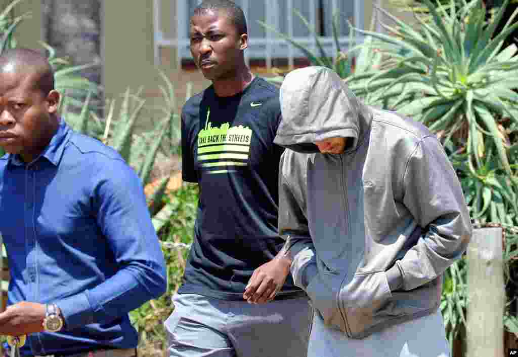 Oscar Pistorius lầm lũi bước ra khỏi đồn cảnh sát Boschkop ở phía đông Pretoria, Nam Phi, ngày 14 tháng 2, 2013.