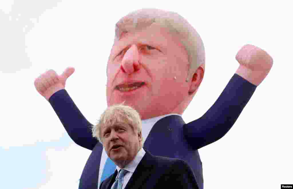 Britain's Prime Minister Boris Johnson speaks, with an inflatable figure depicting him in the background, following local elections at Jacksons Wharf Marina in Hartlepool, Britain.