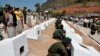 In this photo released by the Myanmar Defense Ministry, soldiers place urns containing ashes of soldiers fallen during a recent fighting against ethnic Kokang rebels at a military funeral in Lashio, Myanmar, Feb. 23, 2015.