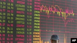 投资者走过上海证券公司的股市行情屏幕