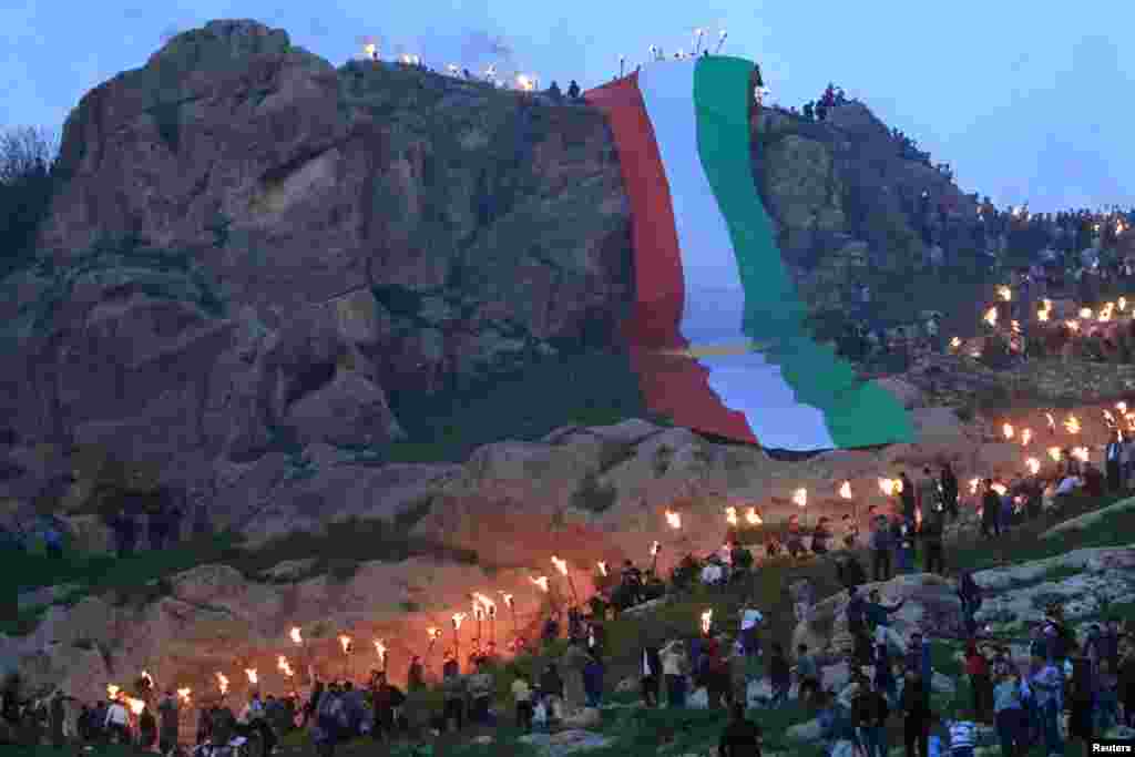 Iraqi Kurdish people carry fire torches up a mountain, as they celebrate Newroz Day, a festival marking their spring and new year, in the town of Akra, Iraq, March 20, 2018.