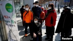 韩国新冠病毒确诊病例不断攀升，重灾区大邱市民众阅读有关邮局贩卖口罩的说明(2020年3月5日)