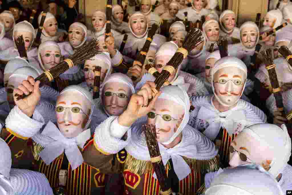 A group of people dressed as 'Gilles of Binche', arrive to pick up their jubilee medals at the City Hall on the Grand Place, during the Carnival of Binche, in Binche, Belgium. Up to 1,000 clown-like performers known as Gilles, appear in the city center, wearing a hat covered with ostrich feathers and a red, yellow and black medieval costume decorated with bells and with lace at the neck, wrists and ankles.