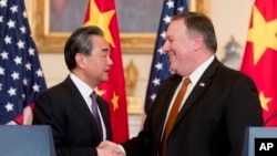 美国国务卿蓬佩奥和中国国务委员兼外长王毅在美国国务院联合举行记者之后握手。（2018年5月23日）