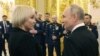 Президент Росії поруч з Марією Костюк, матір'ю російського солдата, якого посмертно нагородили орденом "Герой Росії". Цього дня, 8 грудня, Путін оголосив, що балотуватиметься на переобрання у 2024 р. Фото: Mikhail Klimentyev/Sputnik/Pool AFP