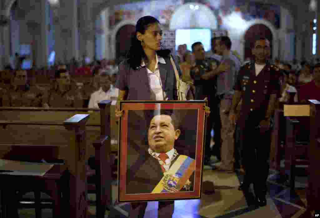 Một phụ nữ cầm hình của Tổng thống Chavez trong buổi cầu nguyện cho ông ở Havana, ngày 13/12/2012.