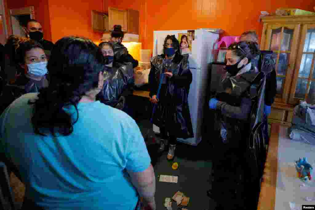 Staff from La Colaborativa talk to a resident being legally evicted with 48-hours notice for violating the terms of her lease, as they pack up her belongings in Chelsea, Massachusetts.