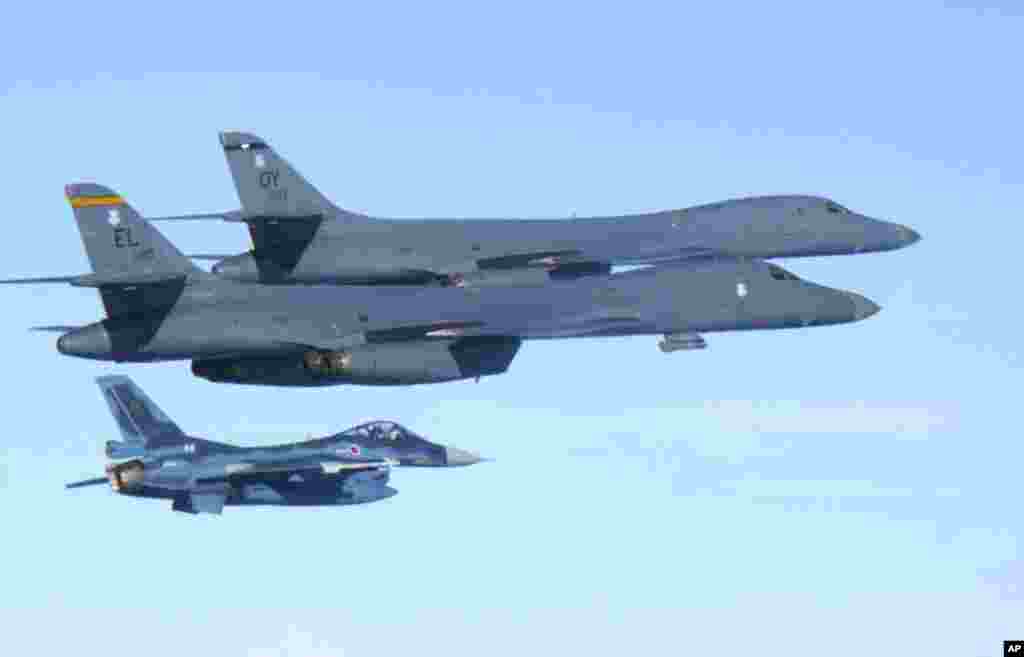 日本航空自卫队发布的这张照片显示，军事演习中，从关岛的安德森空军基地起飞的美国超音速B-1B型轰炸机在日本南部的九州岛上空飞行。日本自卫队的F-2战斗机伴随。（2017年7月30日） 