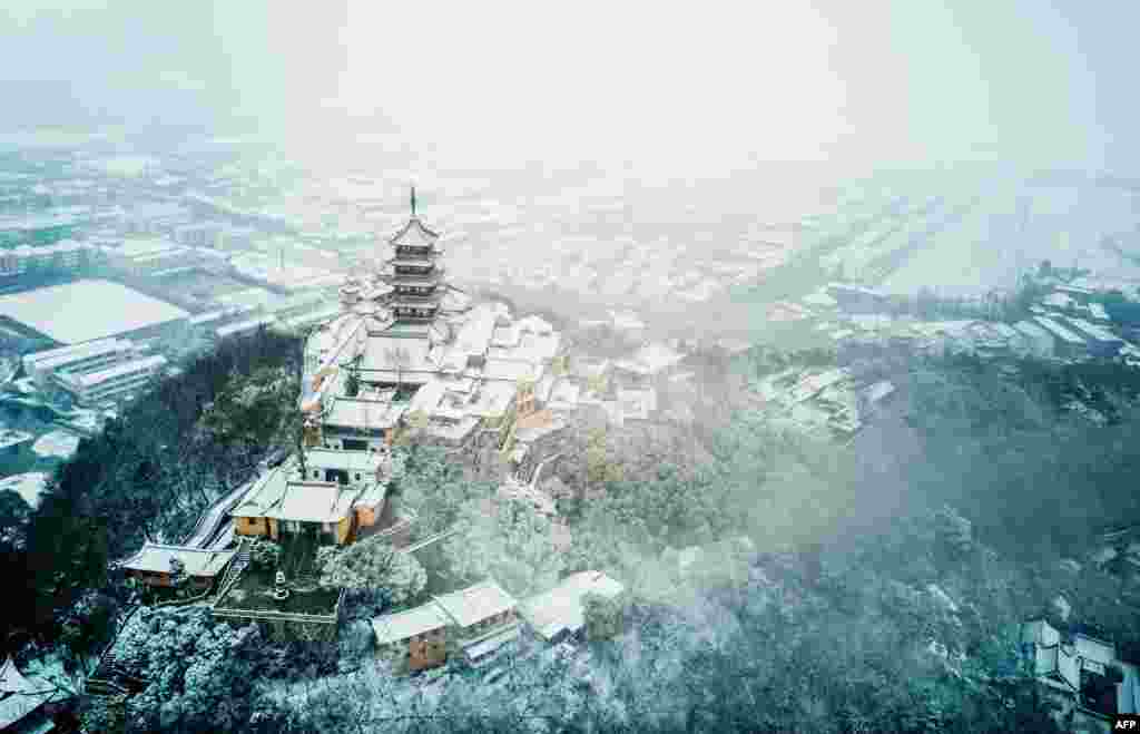 2018年1月25日,中国东部江苏省南通市南郊降雪后的狼山鸟瞰图。狼山是江苏省省级风景名胜区,国家AAAA级旅游区。维基百科说, 根据中国第六次全人口普查,全市常住人口为7282835人。这个数字的出处是南通市统计局 的《南通市2010年第六次全国人口普查主要数据公报》。这个地级市有700多万人。