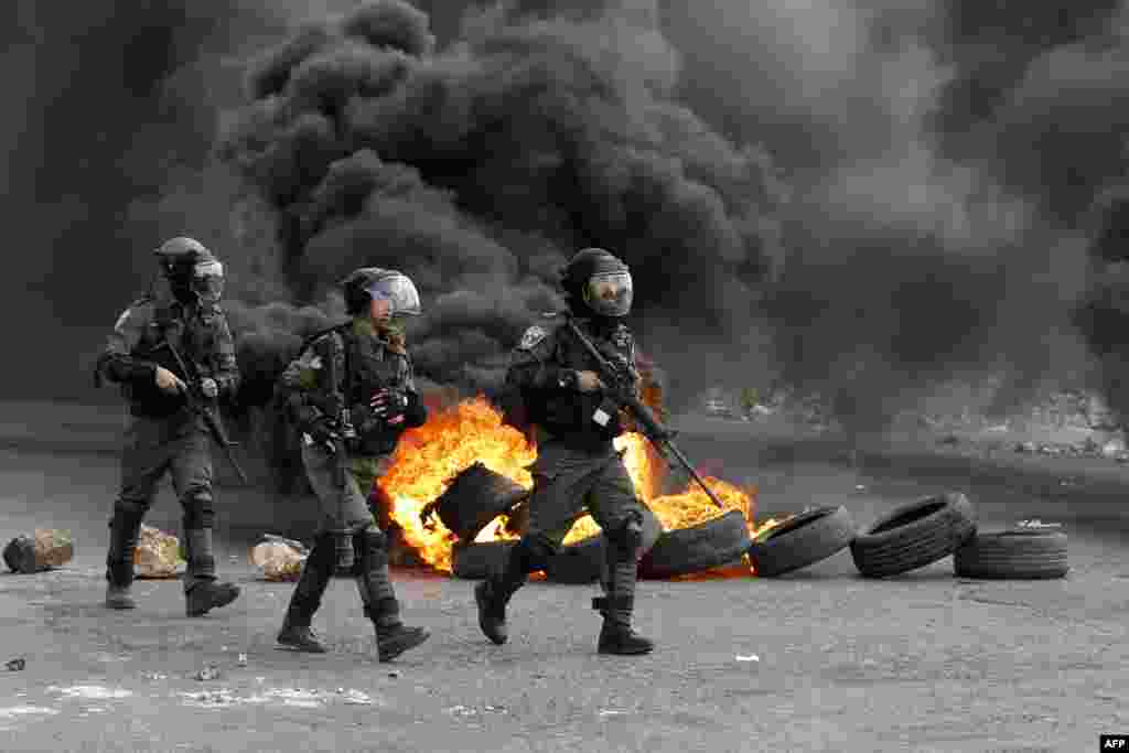 Israeli border guards advance down a street during clashes with Palestinian protesters following a demonstration in the West Bank city of Ramallah on March 9, 2018.