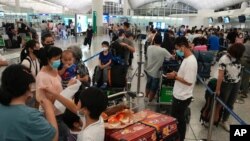 港人在香港机场排队准备飞离香港前往英国。 （2021年6月30日）