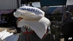 加沙地带的巴勒斯坦人在联合国救援站领取食品 - 资料照片