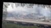 A window shattered by the shockwaves frames the site of an explosion at a warehouse in northeastern China's Tianjin municipality, Aug. 14, 2015. 